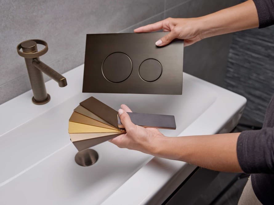 Geberit Sigma40, der matcher håndvaskarmaturet i metalfinish aged bronze