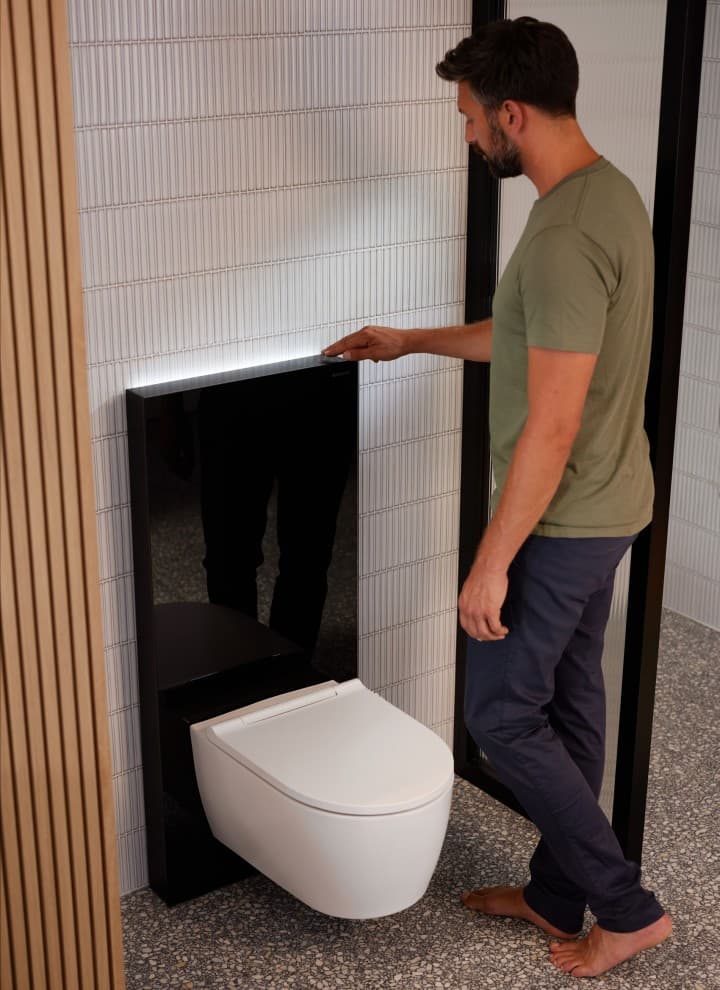 Mand ved siden af Geberit Monolith Plus med ComfortLight
